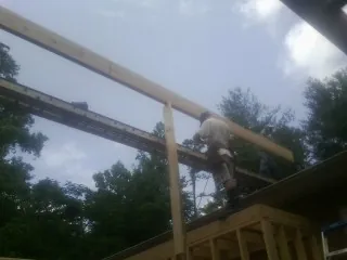 Carpenter setting a ridge beam over a new addition frame — Ice Dam Removal by Roofing Brothers in West Fork