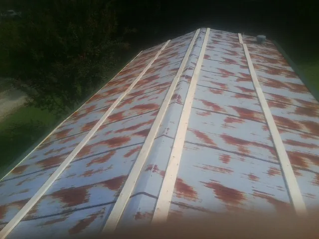 Rusted metal roof panels with new wood purlins before replacement — Storm Damage Roof Repair in West Fork by Roofing Brothers