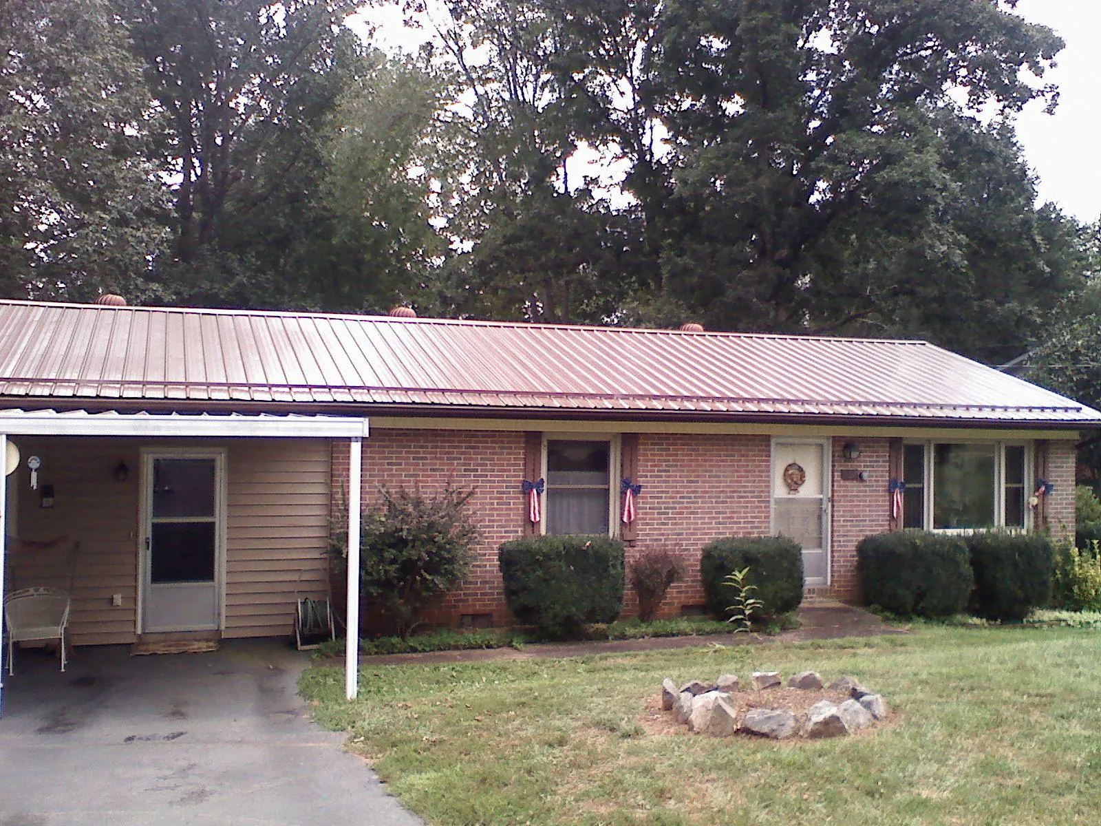 Bronze metal roof and carport on a brick ranch home — Roof Repair work by our crew in West Fork